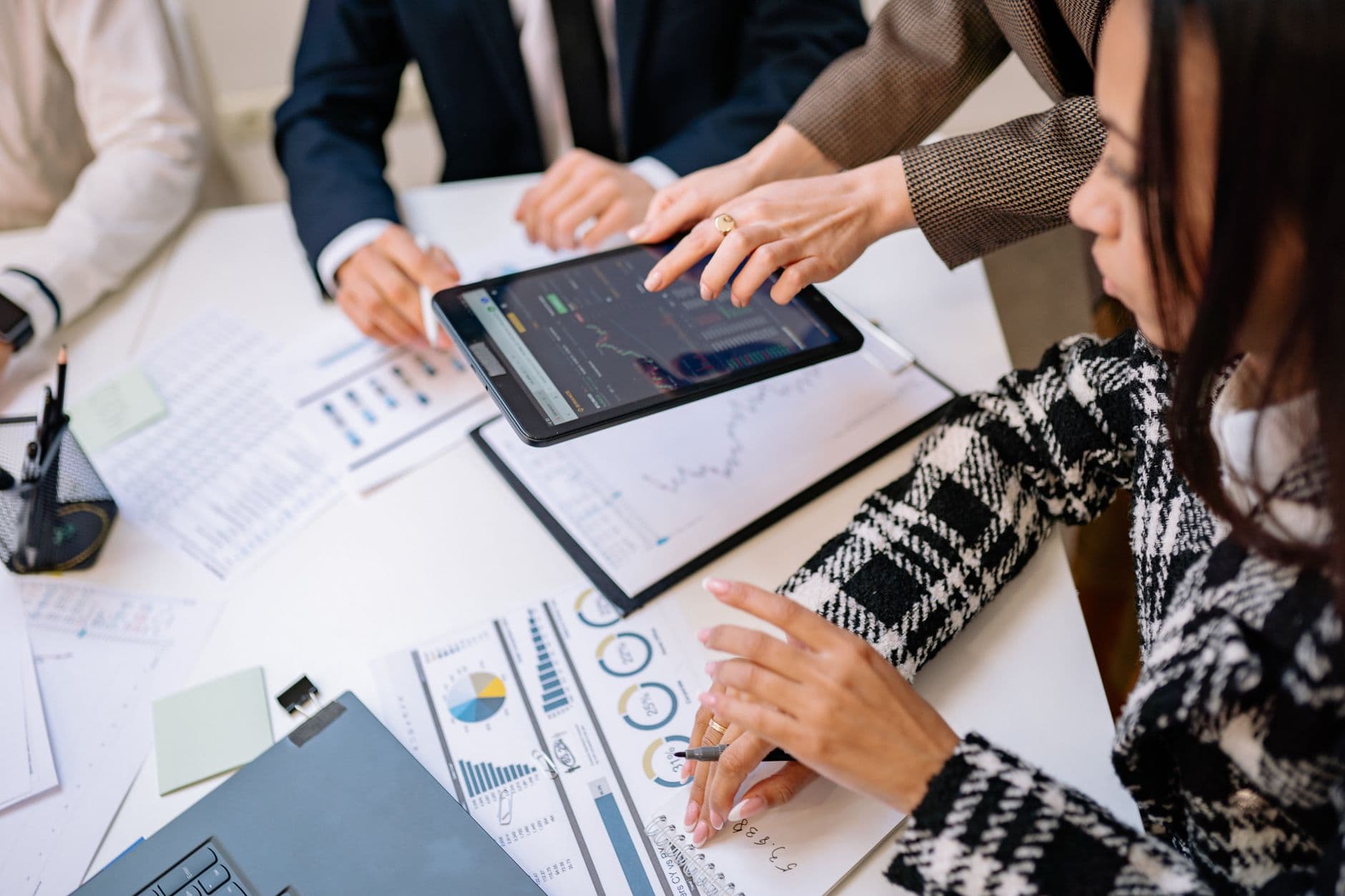 Business professionals reviewing analytics on a tablet during a meeting.